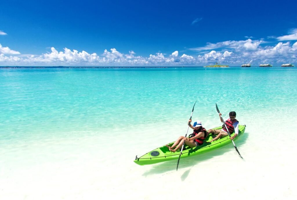 Dos personas remando en un kayak verde sobre el mar