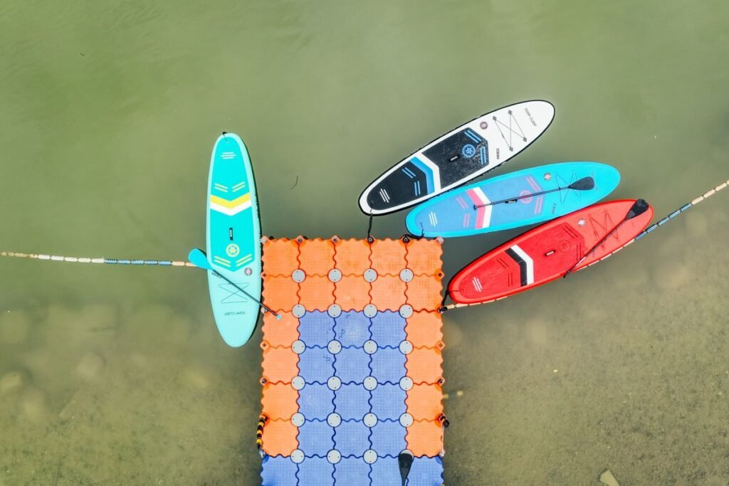 Tablas de paddle surf de colores amarradas a un pantalán flotante